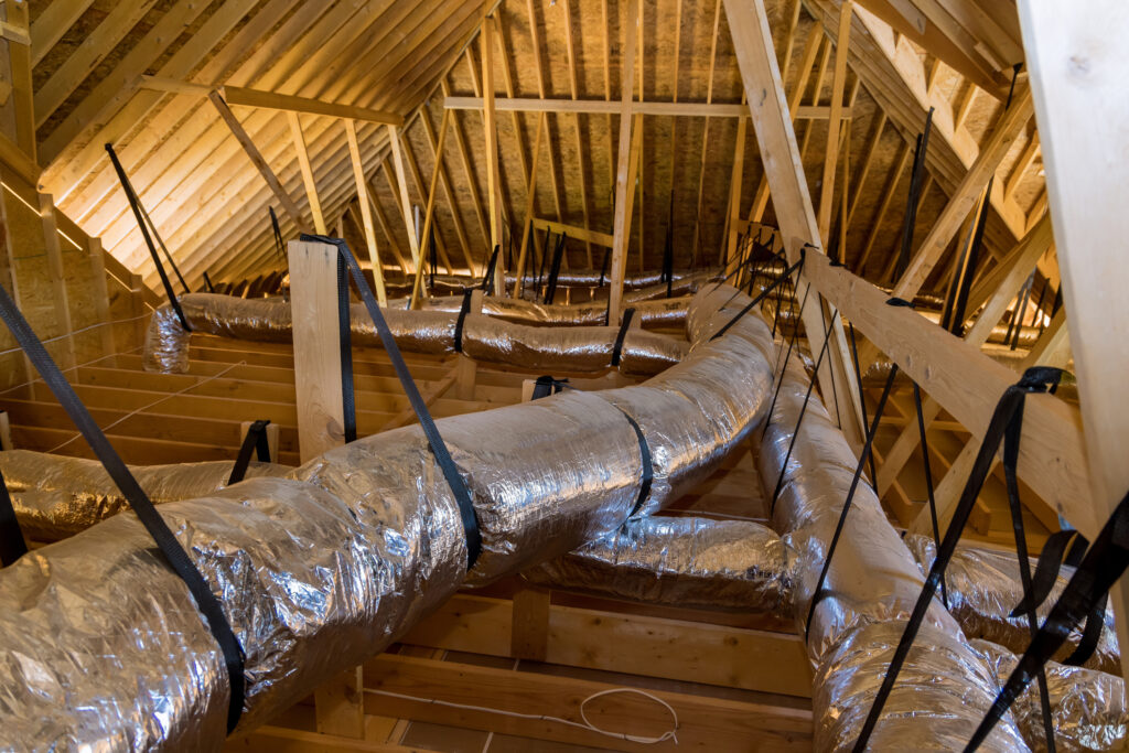 Ventilation pipes on the unfinished ceiling of attic in a newly constructed home